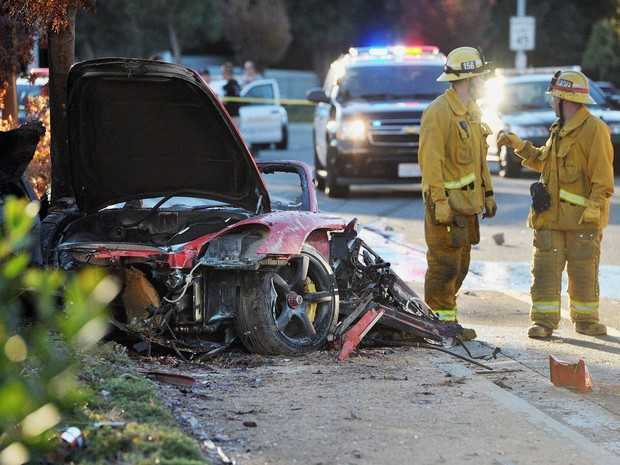 Bombeiros trabalham em Porsche destruído em acidente neste sábado em Valencia, na cidade de Santa Clarita, Califórnia. (Foto: AP Photo/The Santa Clarita Valley Signal, Dan Watson)