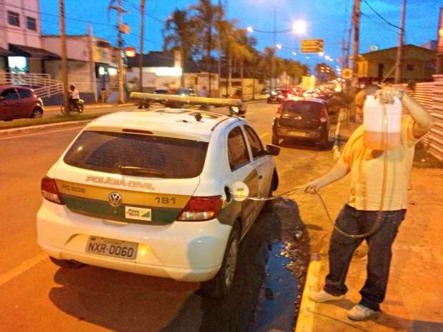 Homem abastece viatura da polícia, na Avenida Ceará  (Foto: Davi Sahid/ Arquivo pessoal)