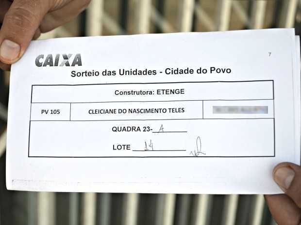 Bruno Moreira, esposo de Cleiciane, mostra o documento que aponta a localização da casa na Cidade do Povo (Foto: Tácita Muniz/G1)