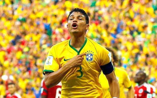 Thiago Silva aponta par ao escudo e comemora o primeiro gol: "Isso aqui é Brasil" (Foto: Reuters)