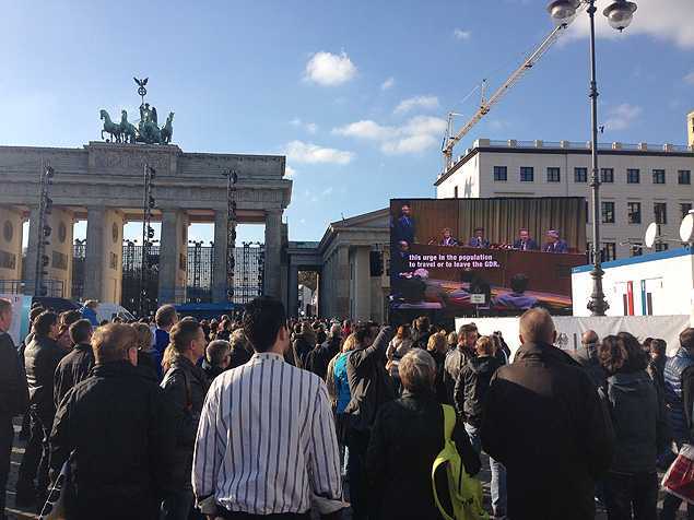 Visitantes assistem a documentário sobre o Muro de Berlim perto do Portão de Brandemburgo - Leandro Colon