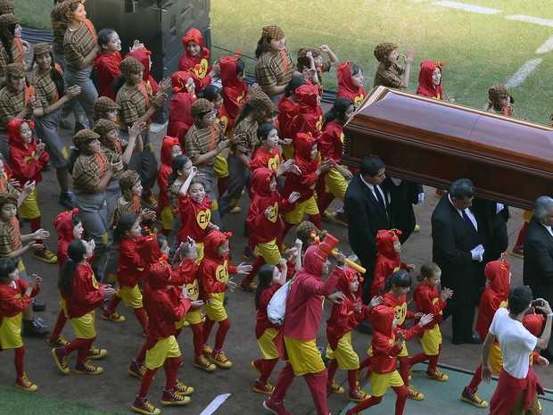 Caixão com corpo de Roberto Bolaños chega ao estádio Azteca rodeado de pessoas vestidas de 'Cahpolin' (Foto: Alfredo Estella/AFP)