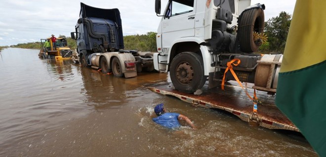 Trecho da BR-364 seguem inundado; caminhões são puxados por tratores para fazer a travessia/Foto; Sérgio Vale/Secom