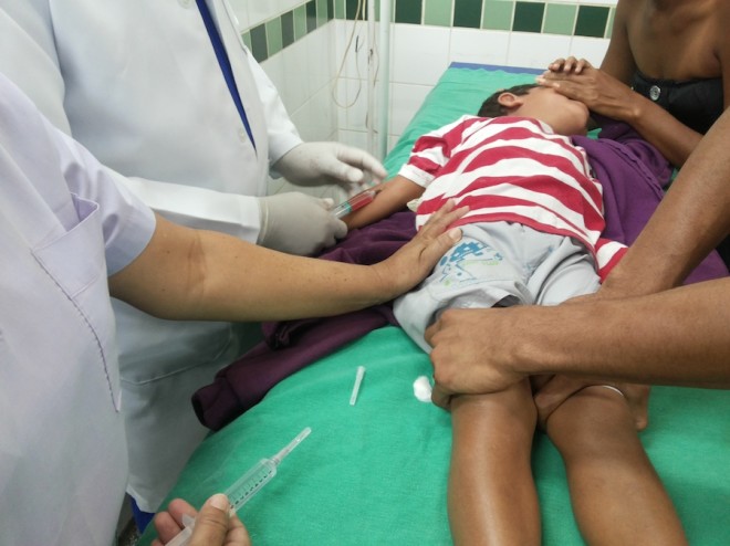 Pais e enfermeiros tiveram que segurar a criança para que pudessem aplicar o antialérgico em seu braço com seringa para adulto.