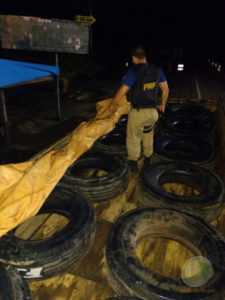 Momento em que agentes da PRF encontram os pneus debaixo da lona na carroceria do caminhão do DEPASA - Foto/divulgação-PRF