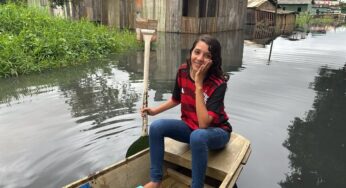 De canoa, adolescente de 17 anos ajuda no transporte de vizinhos em bairro alagado em Rio Branco